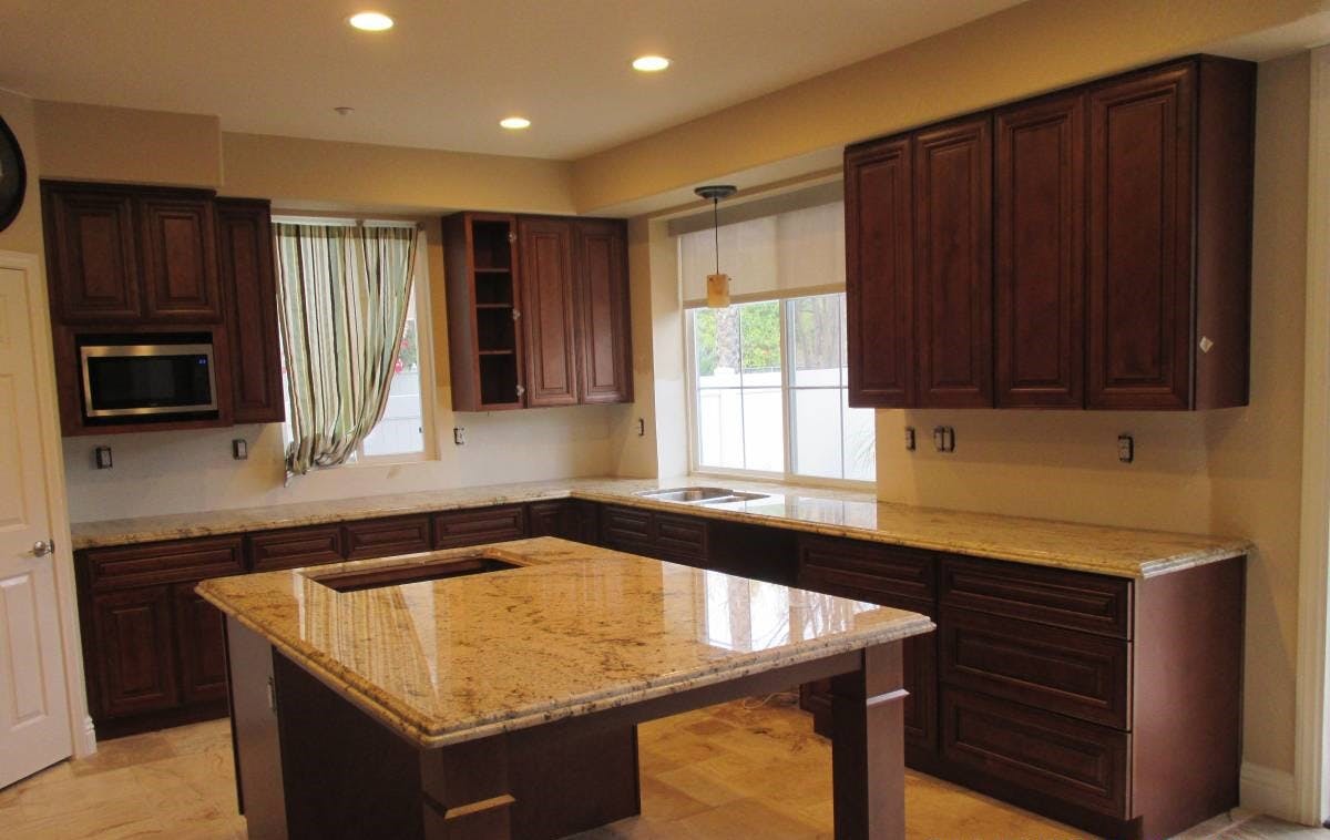 Dark brown kitchen cabinets and granite countertop