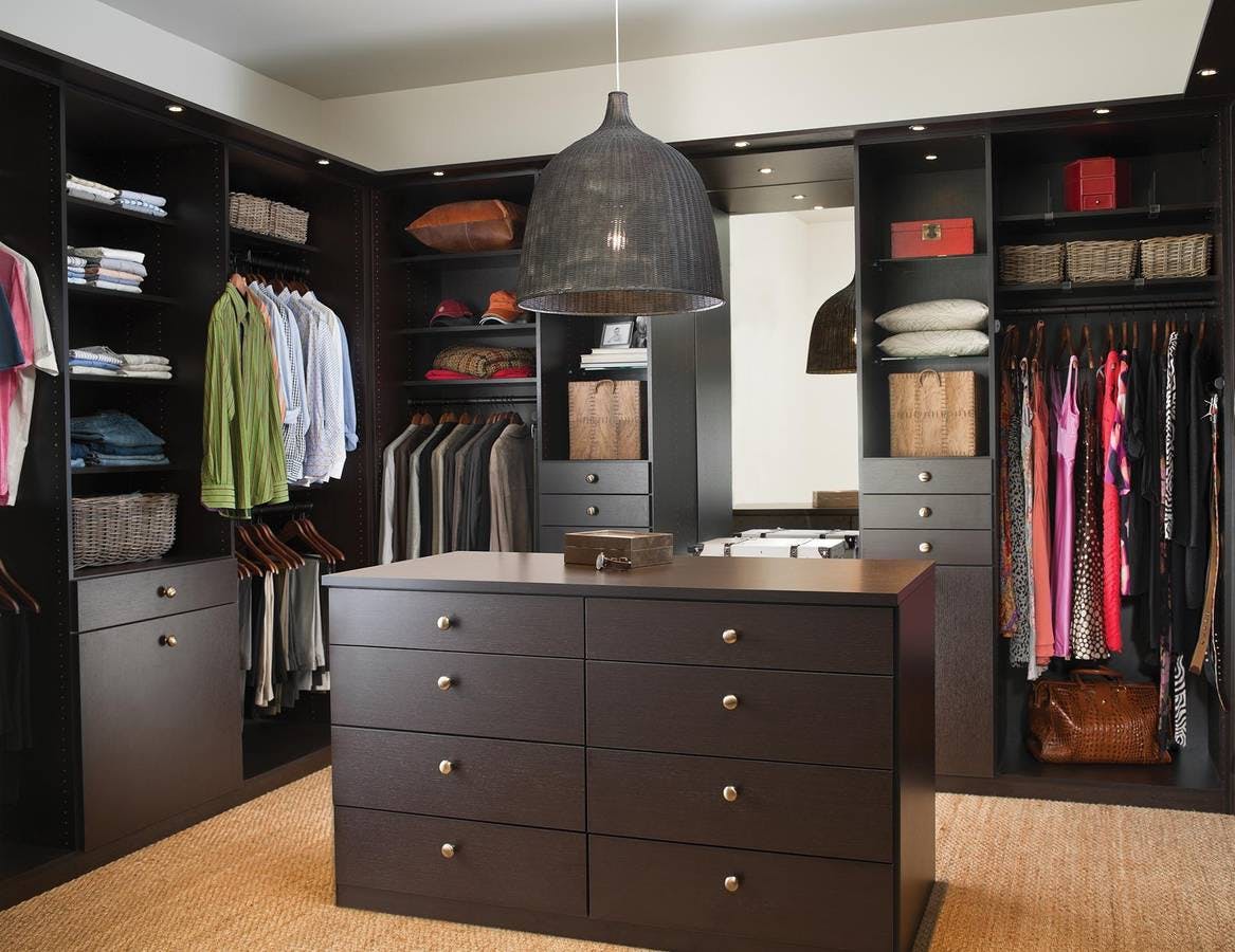 Walk-in closet with brown shelves and cabinets