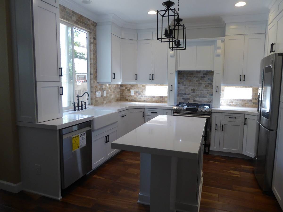 Kitchen with white granite countertops and white cabinets